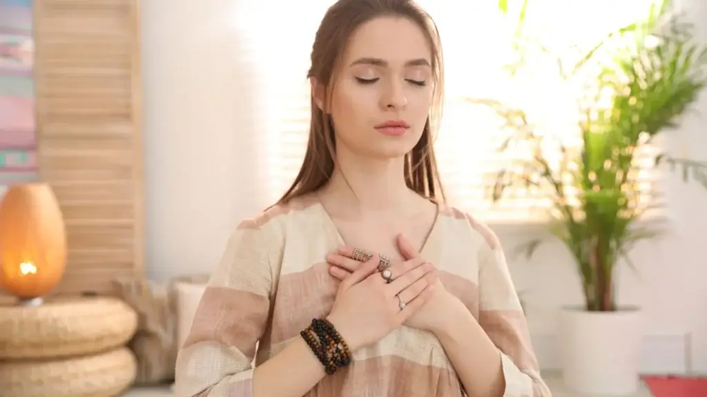 Young woman with eyes closed, hand on chest, expressing emotional awareness and self-reflection, representing self-awareness benefits.